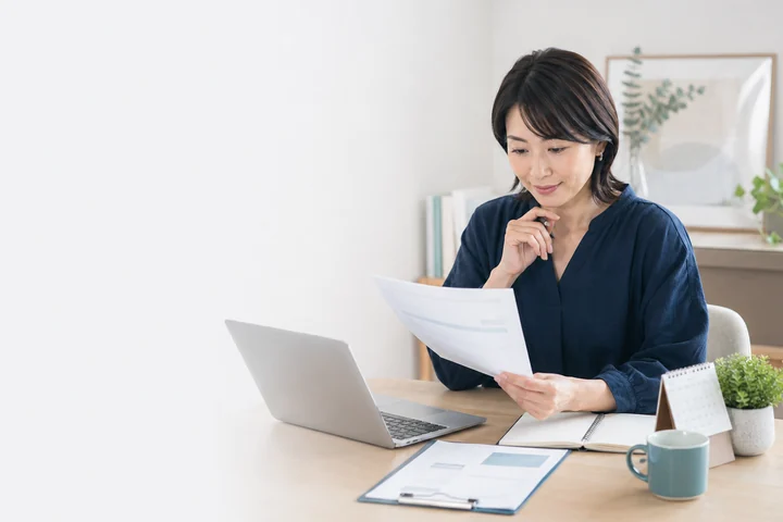 職務経歴書と求人情報を確認する教員